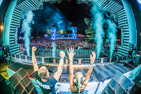 NFIX & CANDICE behind the decks with smoke effects and an outdoor crowd